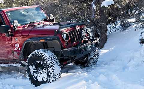 a red jeep driving in snow