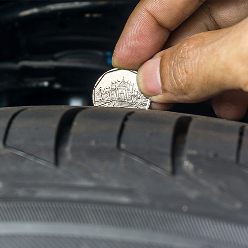 A penny placed into the tread groove to check the tread life left on the tire (penny test).